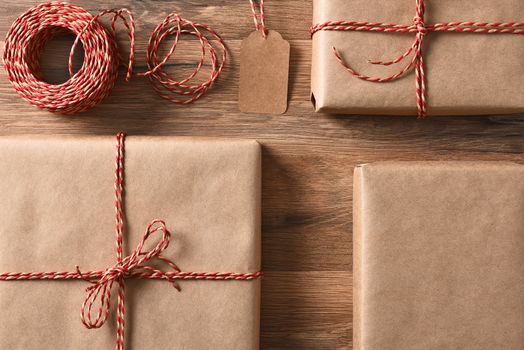 Christmas presents wrapped with eco friendly and recyclable paper and cord. High angle closeup in horizontal format.