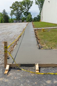 Vertical shot of a freshly poured concrete sidewalk at a construction site.