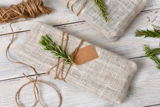 Fabric wrapped Christmas presents on a rustic wood table.