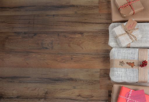 Top view of a group of Christmas presents on a dark wood table with copy space.