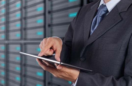 businessman hand using tablet computer and server room background