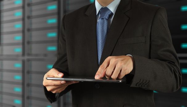 businessman hand using tablet computer and server room background