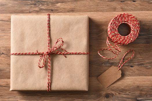 High angle view of a plain brown paper wrapped Christmas Present next to a la ball of twine.