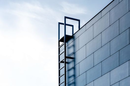 staircase to the sky and the wall of a modern building on a background of blue sky and clouds abstract background