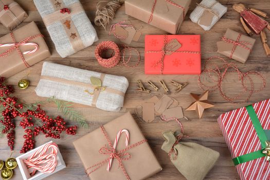 High angle shot of a table filled with wrapped Christmas gifts and wrapping supplies.