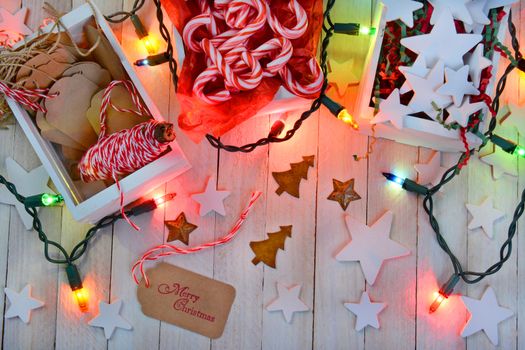 High angle shot of items for wrapping Christmas presents with colorful holiday lights.