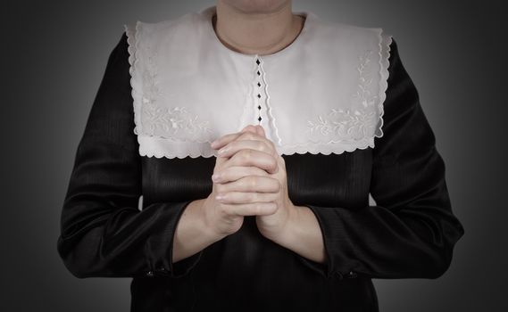 hand of nun praying on black background