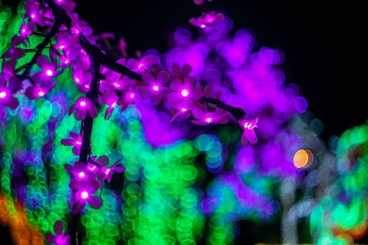 Sakura branch. Abstract background with bubble bokeh defocused lights. Majestic tree of lights. Fantastic forest.  