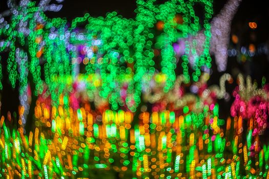 Abstract twinkled bright background with defocused lights. Majestic tree of lights. Fantastic forest. Unique bokeh effect.