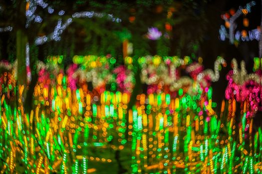 Festive abstract background with bokeh defocused lights. Majestic tree of lights. Fantastic forest. Copy space.