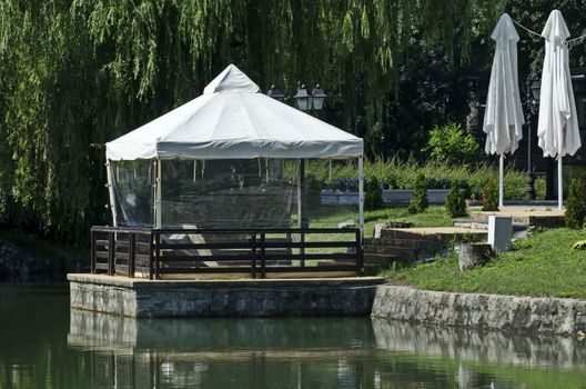 A cozy place for a summer relaxation with a friend under the sunshade in Ariana Lake, park  Borisova gradina, Sofia, Bulgaria