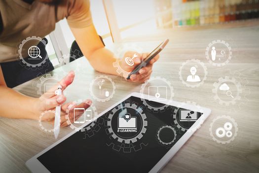 E-learning with connected gear cogs connected diagram virtual dashboard.businessman working with digital tablet computer and smart phone on wooden desk as concept