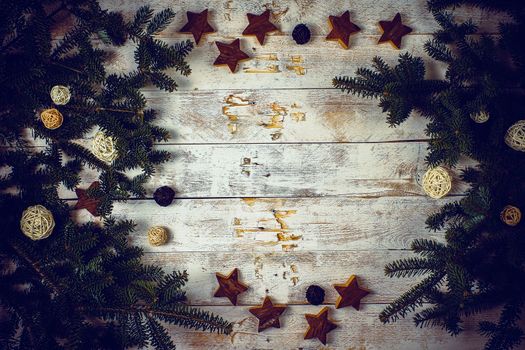 Christmas composition. Frame made of fir tree branches with decoration on rustic wooden background. Flat lay, top view, copy space.