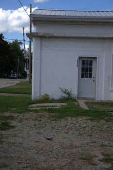 An old white building on a bright and sunny day waiting for a visitor.