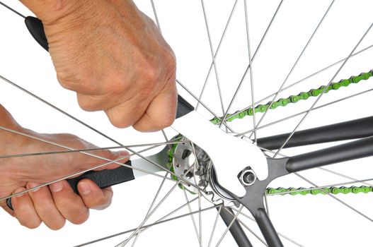 Closeup of a bicycle repair technician tightening the bolts on a wheel. Horizontal format over a white background.