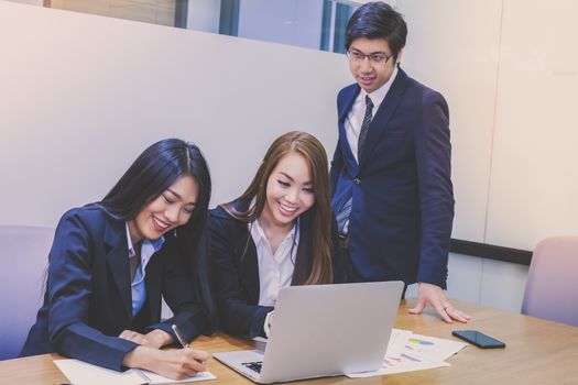 Asian business people make a group discussion in meeting room with document and computer putting on wooden table