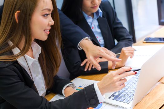 A business group discussion in meeting room with document and computer put on wooden table.