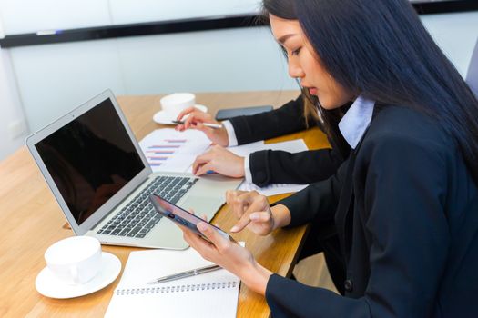 Asian business people make a group discussion in meeting room with document and computer putting on wooden table