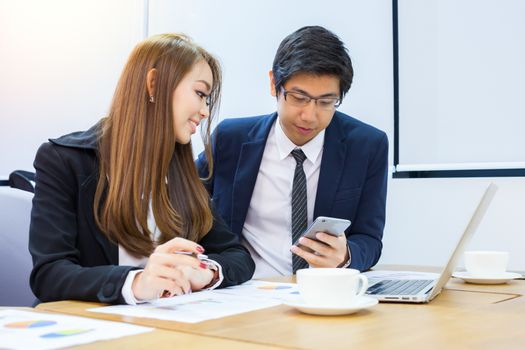 Asian business people make a group discussion in meeting room with document and computer putting on wooden table