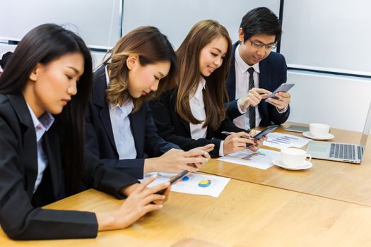 Asian business people make a group discussion in meeting room with document and computer putting on wooden table