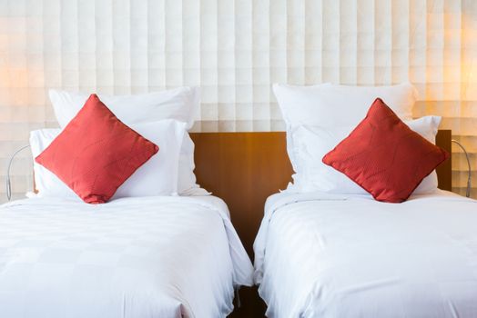 Modern bedroom interior with red pillow on white bed