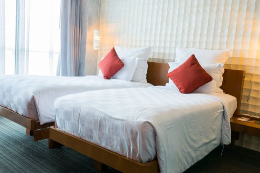 Modern bedroom interior with red pillow on white bed