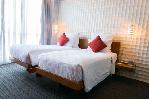 Modern bedroom interior with red pillow on white bed