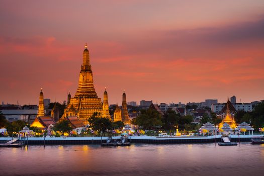 A colorful of sunset time reflection of gold pagoda "Wat Arun" temple of Bangkok at night time