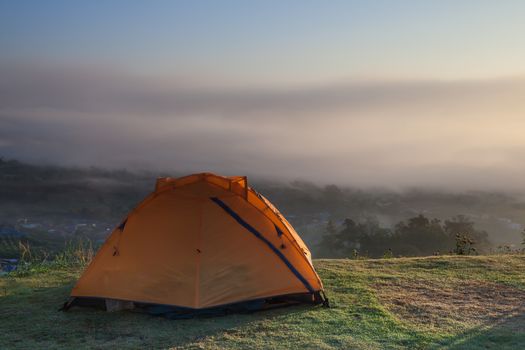 Camping tent on green grass field on mountain under clear sky located at north of Thailand