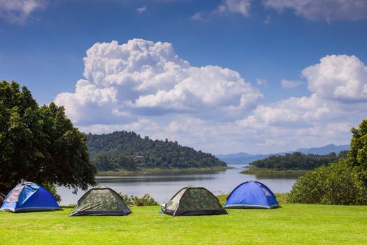 Camping tent on green grass field at hill under clear sky location at north of Thailand