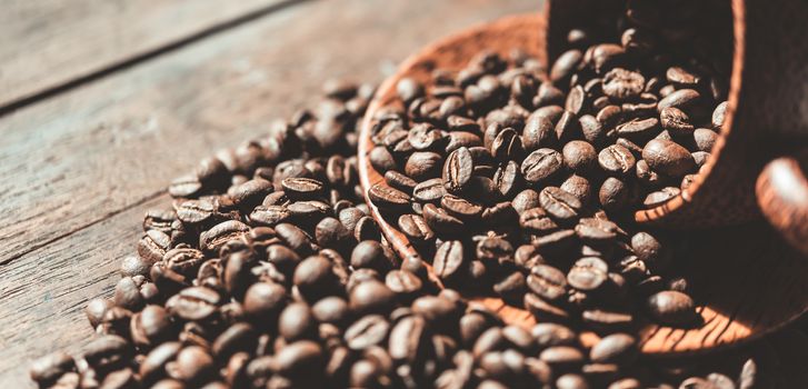 Roasted coffee beans in wood cup on wooden background