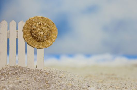 Straw Hat on fence near tropical beach