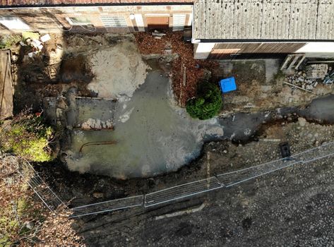 Aerial view with vertical angle of view of an excavation pit filled with liquid soil, drone shot