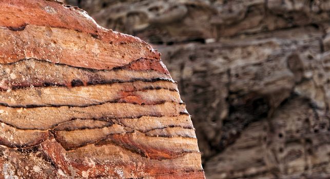 Sandstone coloured red, orange and black by iron and manganese compounds in the World Heritage of Petra, Jordan