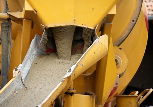 Liquid soil is poured from the concrete mixer down to the ramp to the excavation pit, germany