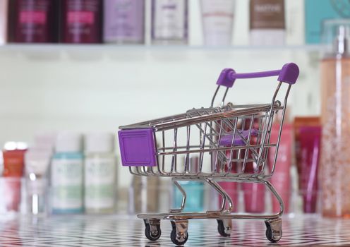Empty shopping basket with blurred cosmetics in background