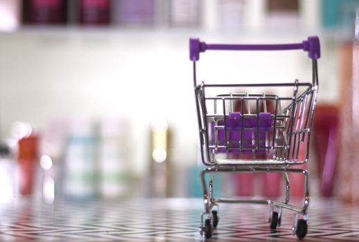 Empty shopping basket with blurred cosmetics in background