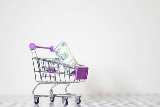 Shopping Cart With Money Roll on White Background