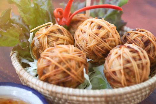 Deep Fried Wrapped Pork with Chinese Noodle or Fried pork ball with noodle or Moo Sarong with sweet chili sauce, authentic recipes, classical Thai cuisine.