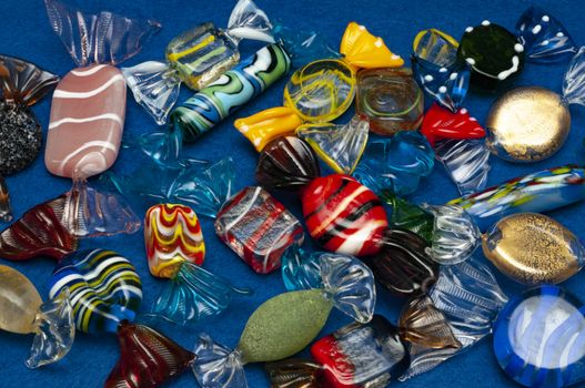 A group of handmade colorful glass candies in light blue background