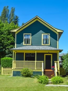 Modest family house with concrete pathway and blue sky background. Family house with patio in front