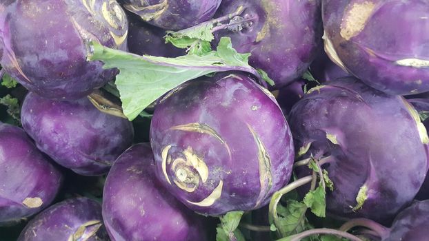 Fruits background: Purple fresh kohlrabi turnip in supermarket for sale