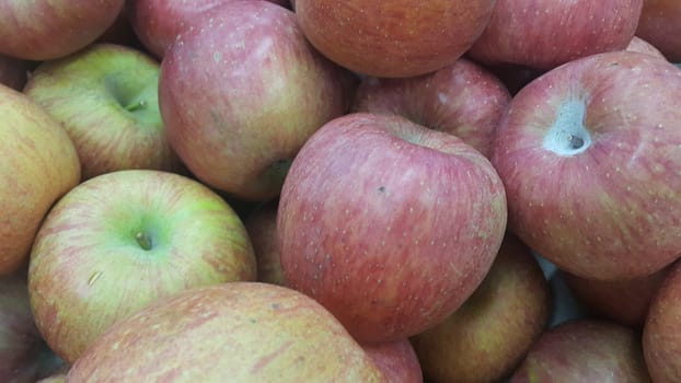 Fresh red and green Apples pile in market for sale. Fruit background for text or messages