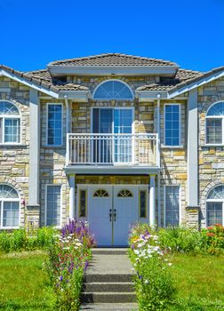 Fragment of luxury family house with entrance and blue sky background