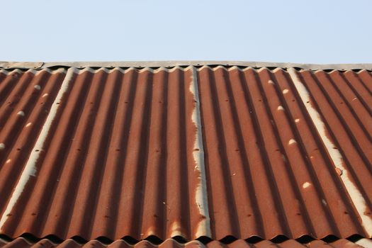 roof, side view of very tin roof old with rusty and little blue sky at the top