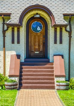 Elegant front door: arch stylish exterior door, wooden door of a house with mosaic glass sections