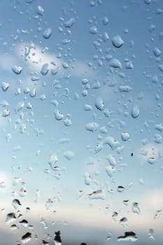 Abstract background, water drops on a window glass, rainy day