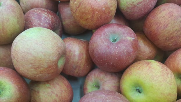 Fresh red and green Apples pile in market for sale. Fruit background for text or messages