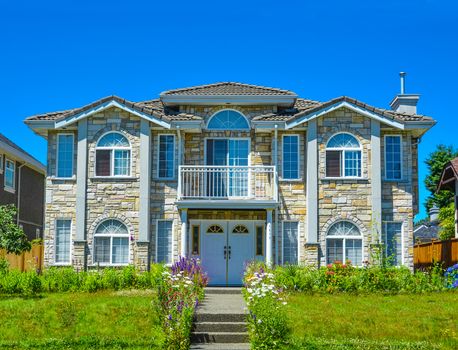 Luxury family house with landscaping and blue sky background