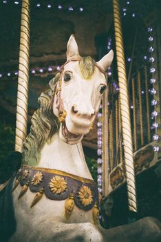 Vintage carousel white horse, retro look with old film color palette and scratches